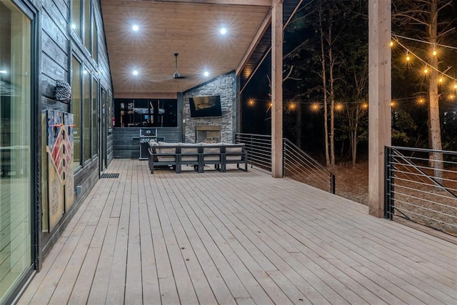 wooden deck with an outdoor stone fireplace