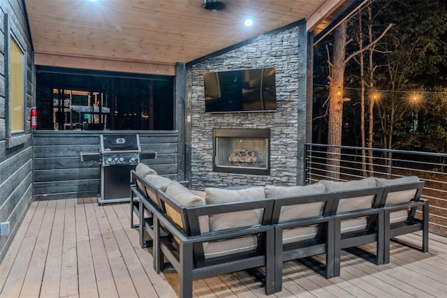 wooden terrace featuring an outdoor living space with a fireplace