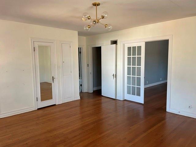 spare room featuring dark hardwood / wood-style flooring and a notable chandelier