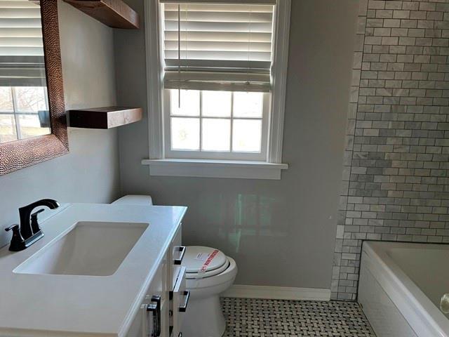 full bathroom featuring vanity, shower with separate bathtub, toilet, and a healthy amount of sunlight