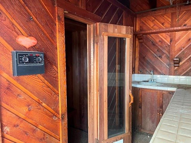 miscellaneous room featuring indoor wet bar and wood walls