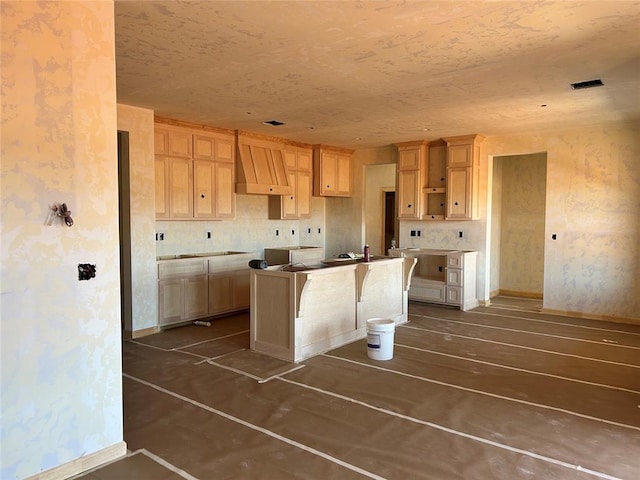 kitchen featuring visible vents, baseboards, a kitchen island, custom exhaust hood, and light brown cabinets