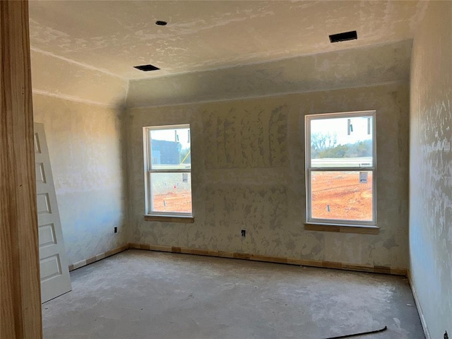 empty room featuring concrete floors and baseboards