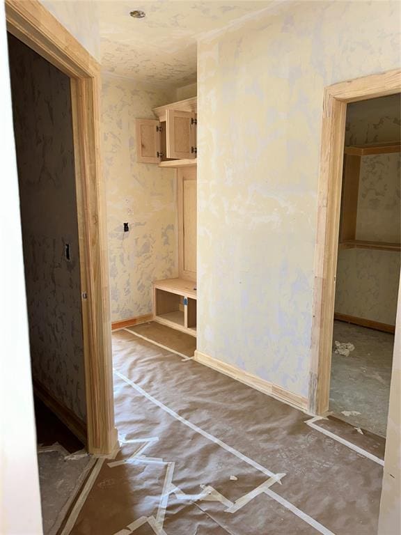 mudroom featuring wallpapered walls and baseboards