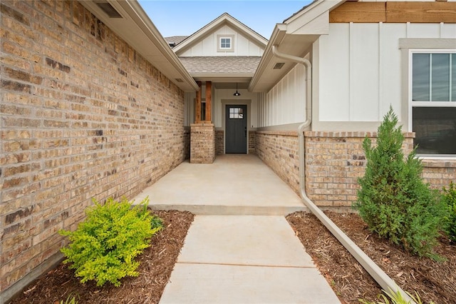 4813 Mistywood Ln, Mustang, OK 73064 - property entrance featuring board and batten siding, brick siding, and roof with shingles