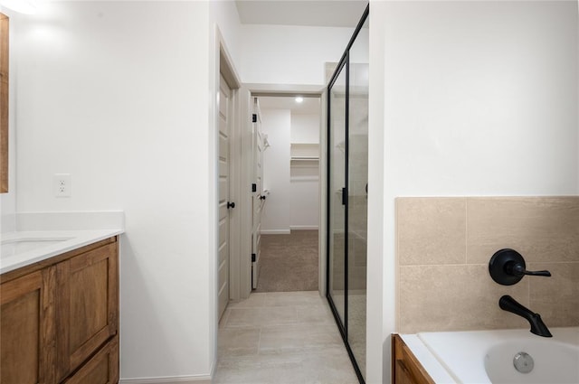 4813 Mistywood Ln, Mustang, OK 73064 - bathroom featuring vanity, a spacious closet, a garden tub, and a stall shower