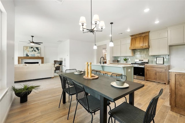 4813 Mistywood Ln, Mustang, OK 73064 - dining area with ceiling fan, light wood-type flooring, recessed lighting, a fireplace, and a chandelier