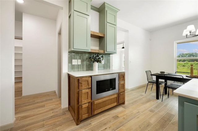 4813 Mistywood Ln, Mustang, OK 73064 - kitchen featuring green cabinetry, stainless steel microwave, light countertops, light wood finished floors, and backsplash