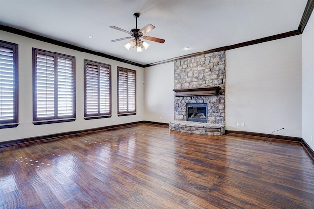 unfurnished living room featuring ceiling fan, dark hardwood / wood-style floors, a stone fireplace, and ornamental molding