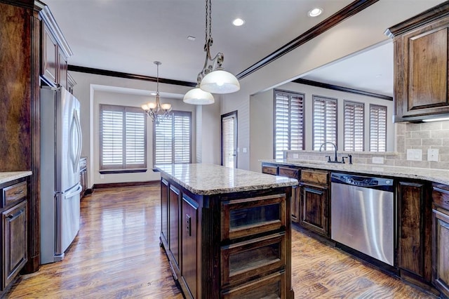 kitchen featuring a center island, appliances with stainless steel finishes, tasteful backsplash, sink, and dark brown cabinetry