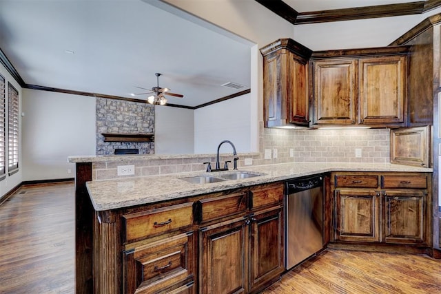 kitchen featuring dishwasher, tasteful backsplash, sink, kitchen peninsula, and light wood-type flooring