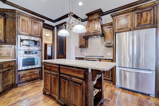 kitchen featuring pendant lighting, appliances with stainless steel finishes, hardwood / wood-style flooring, backsplash, and ornamental molding