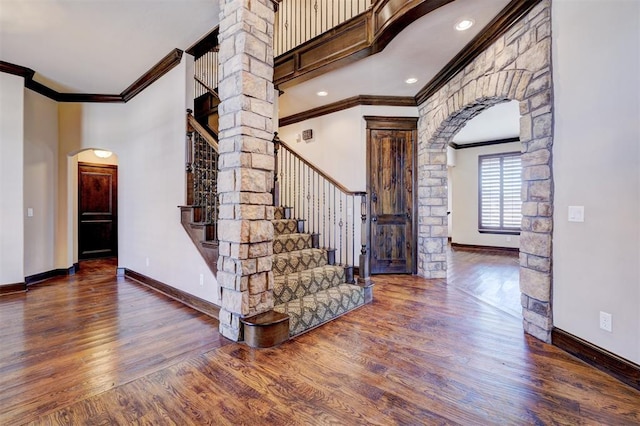 entrance foyer featuring decorative columns, dark hardwood / wood-style flooring, and ornamental molding