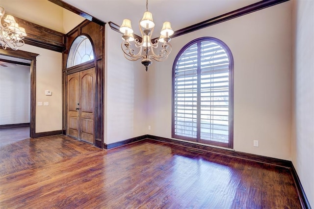 unfurnished room with dark wood-type flooring, crown molding, and a notable chandelier