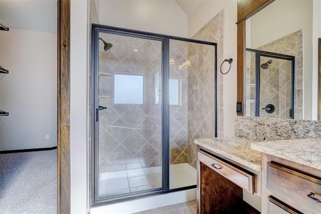 bathroom featuring vaulted ceiling, a shower with shower door, and vanity