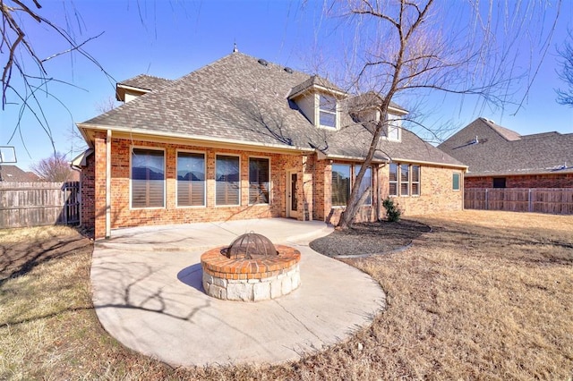 rear view of house featuring a patio area, a yard, and a fire pit