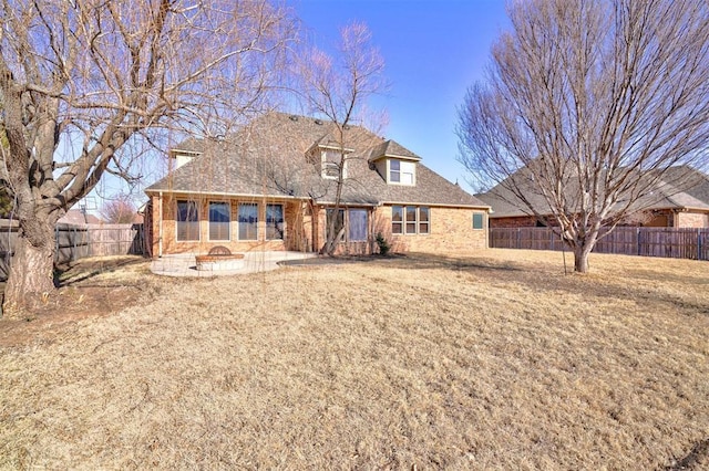 back of house featuring a fire pit, a yard, and a patio