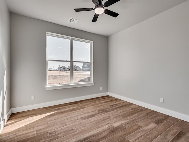 unfurnished room with ceiling fan, hardwood / wood-style floors, and a wealth of natural light