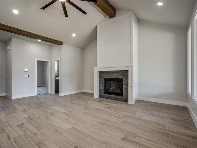 unfurnished living room with high vaulted ceiling, beam ceiling, light hardwood / wood-style floors, and ceiling fan