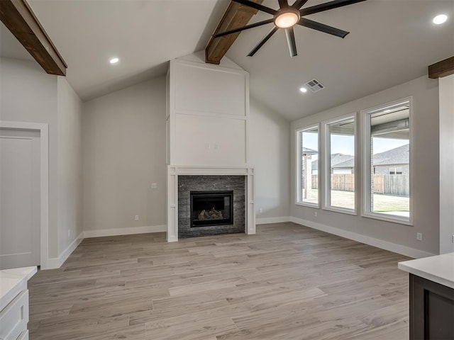 unfurnished living room featuring ceiling fan, vaulted ceiling with beams, and light wood-type flooring