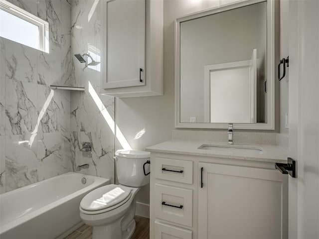 full bathroom with vanity, wood-type flooring, toilet, and tiled shower / bath