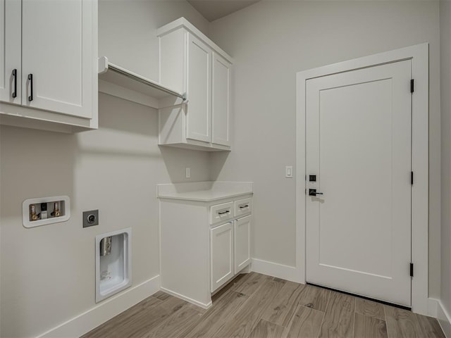 clothes washing area with washer hookup, light hardwood / wood-style flooring, cabinets, and hookup for an electric dryer