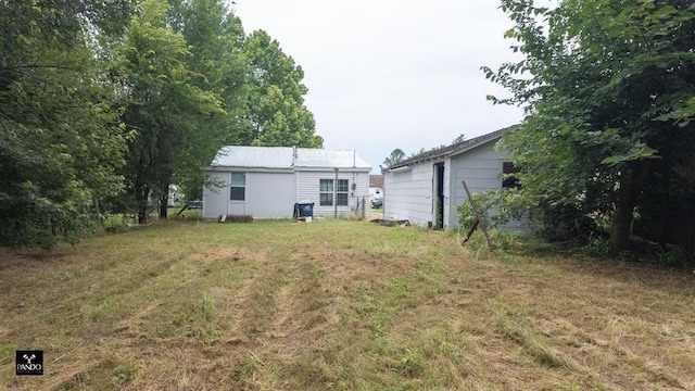313 W Texas Ave, Anadarko, OK 73005 - back of house featuring a lawn