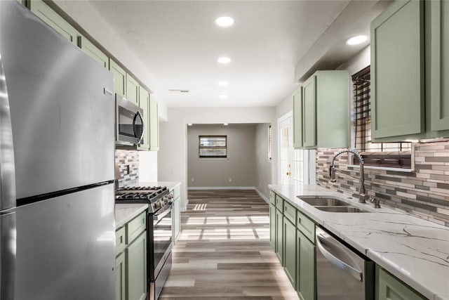 kitchen with sink, stainless steel appliances, and green cabinetry