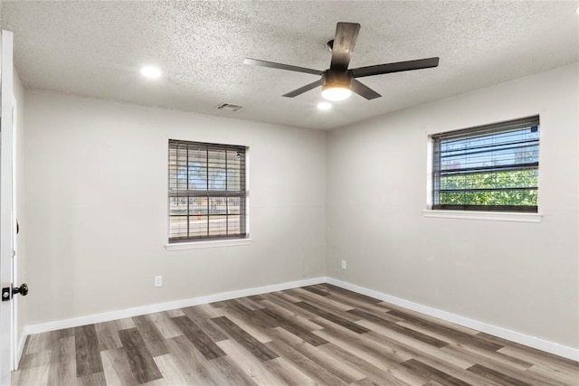 spare room featuring hardwood / wood-style flooring, a textured ceiling, and ceiling fan