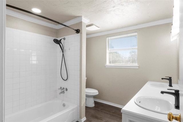 full bathroom with toilet, hardwood / wood-style flooring, ornamental molding, vanity, and tiled shower / bath