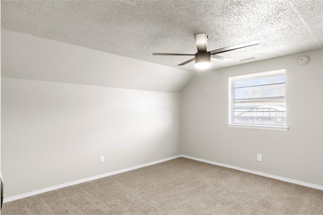 additional living space with vaulted ceiling, ceiling fan, a textured ceiling, and carpet floors