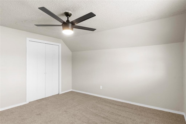 bonus room featuring ceiling fan, a textured ceiling, carpet, and lofted ceiling