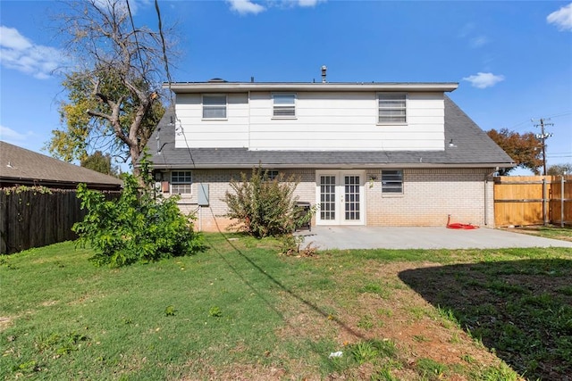 rear view of property featuring a patio, french doors, and a lawn