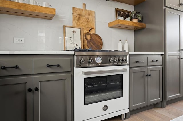 kitchen featuring gray cabinets, high end stove, and light wood-type flooring