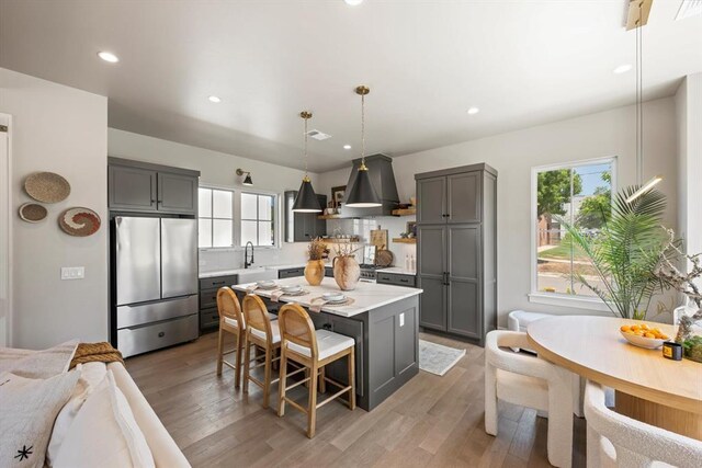 kitchen featuring decorative light fixtures, gray cabinets, and stainless steel fridge