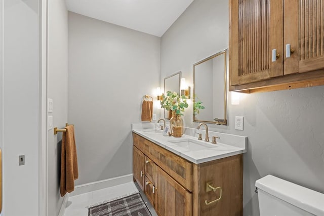 bathroom with toilet, tile patterned floors, and vanity