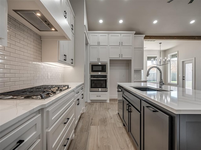 kitchen featuring light stone countertops, white cabinetry, appliances with stainless steel finishes, and sink