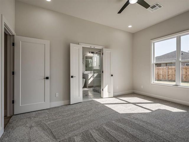 unfurnished bedroom featuring connected bathroom, light carpet, and ceiling fan