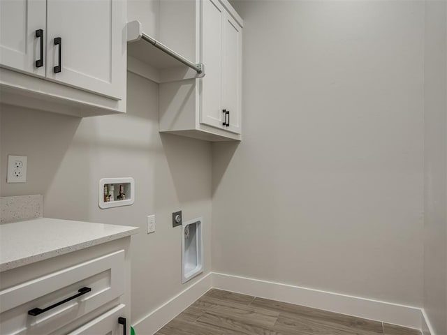 washroom featuring washer hookup, light wood-type flooring, cabinets, and hookup for an electric dryer