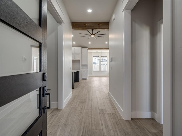 corridor featuring beamed ceiling and light wood-type flooring