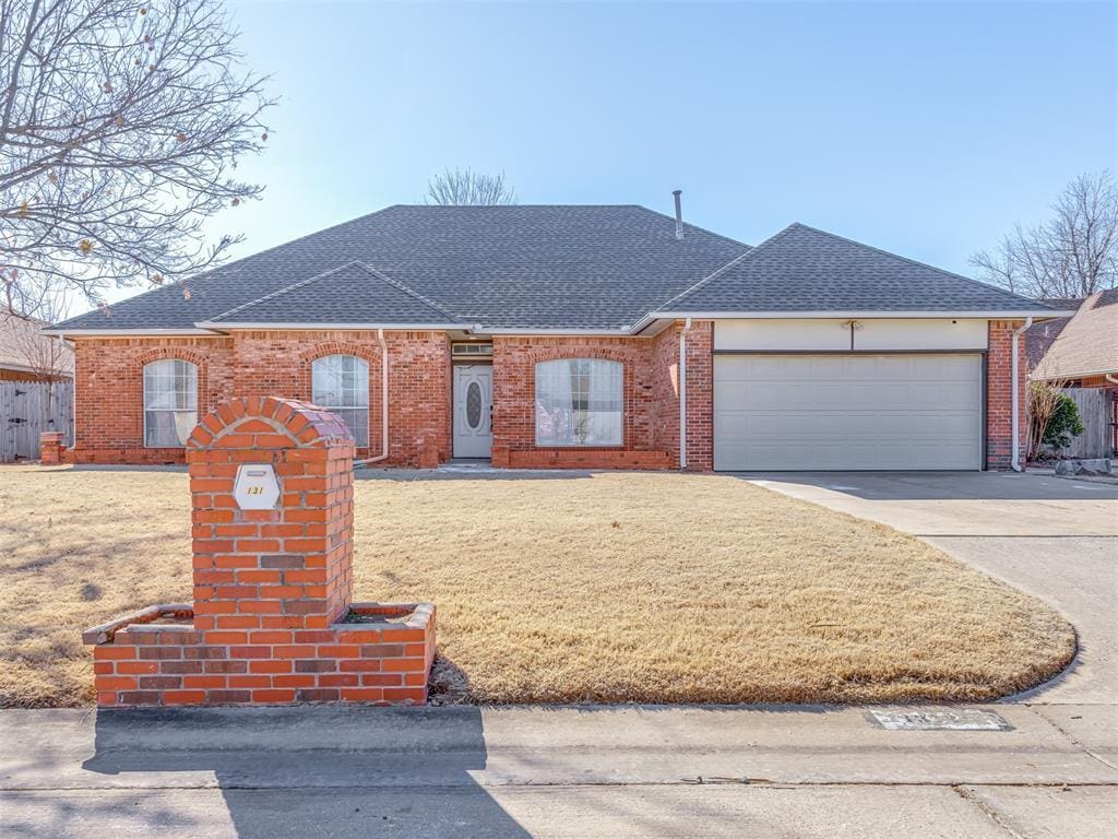 single story home with a garage and a front lawn