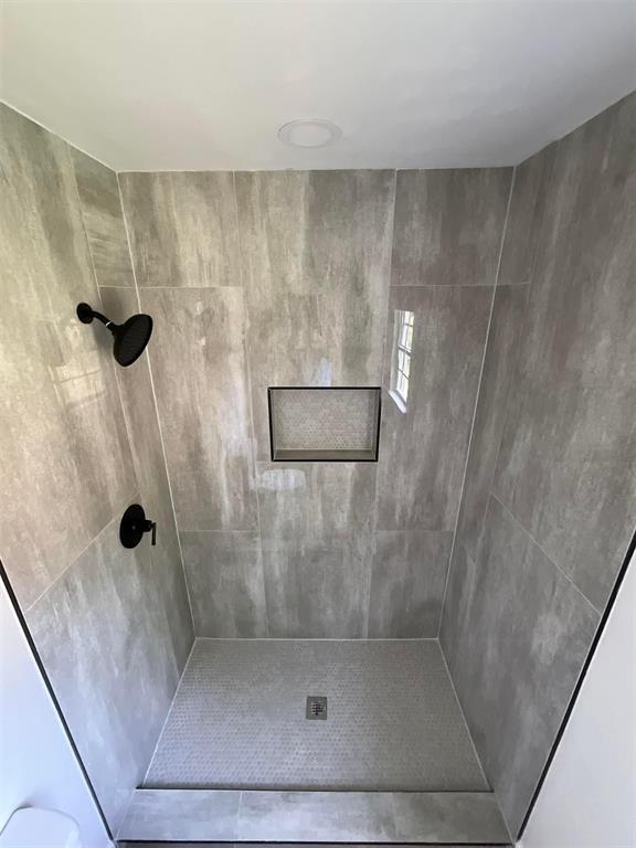 bathroom featuring a tile shower