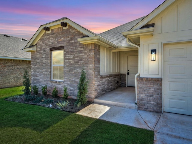 exterior entry at dusk featuring a lawn