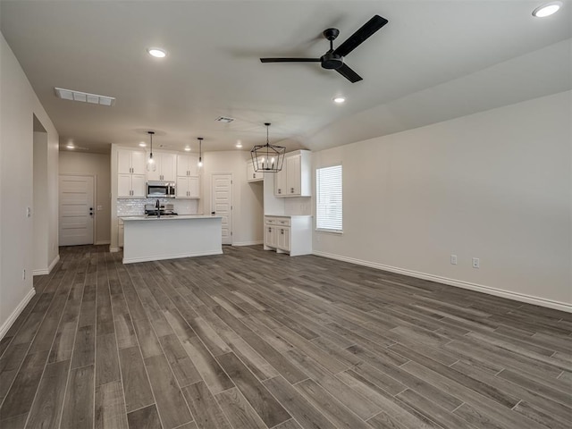 unfurnished living room with dark wood-type flooring and ceiling fan