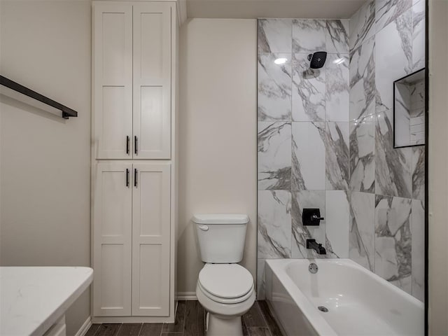 bathroom featuring tiled shower / bath combo and toilet