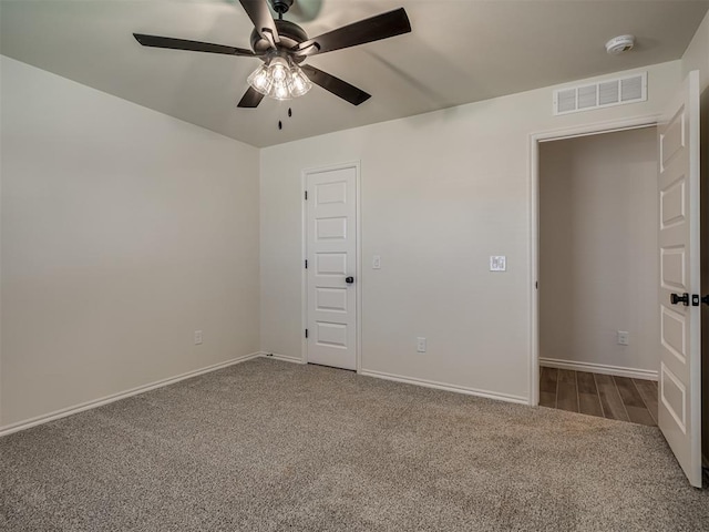 empty room featuring ceiling fan and carpet