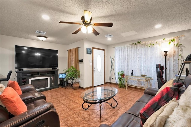 tiled living room with ceiling fan and a textured ceiling