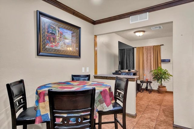 dining room with crown molding, a textured ceiling, and tile patterned floors