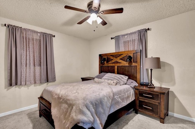 bedroom with ceiling fan, light colored carpet, and a textured ceiling