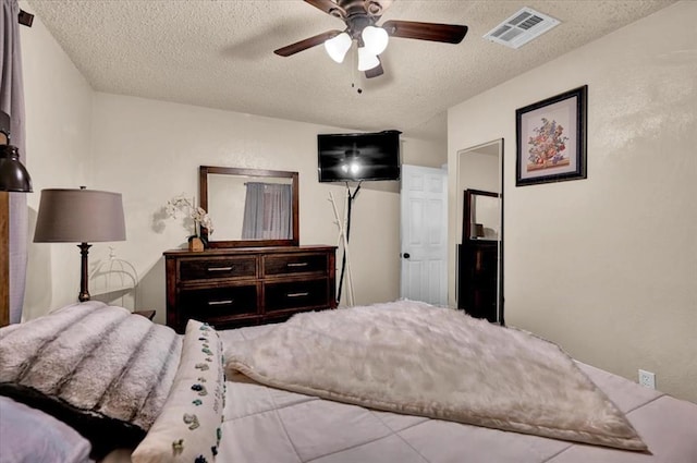 bedroom with a textured ceiling and ceiling fan